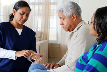 caregiver checking the elder man's blood